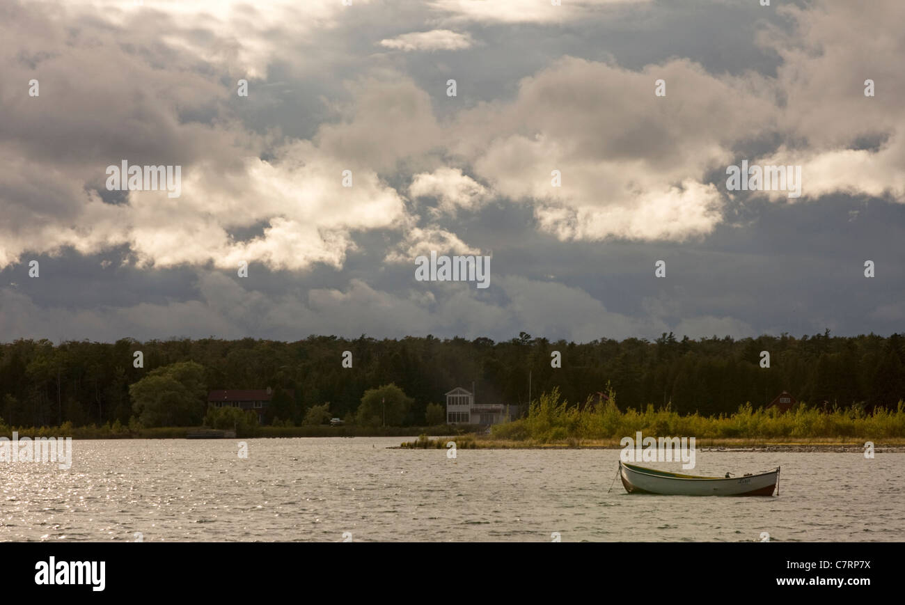 Les nuages s'accumuler sur Jackson Harbour sur l'île de Washington, du Wisconsin, un seul bateau est assis dans l'eau. Banque D'Images