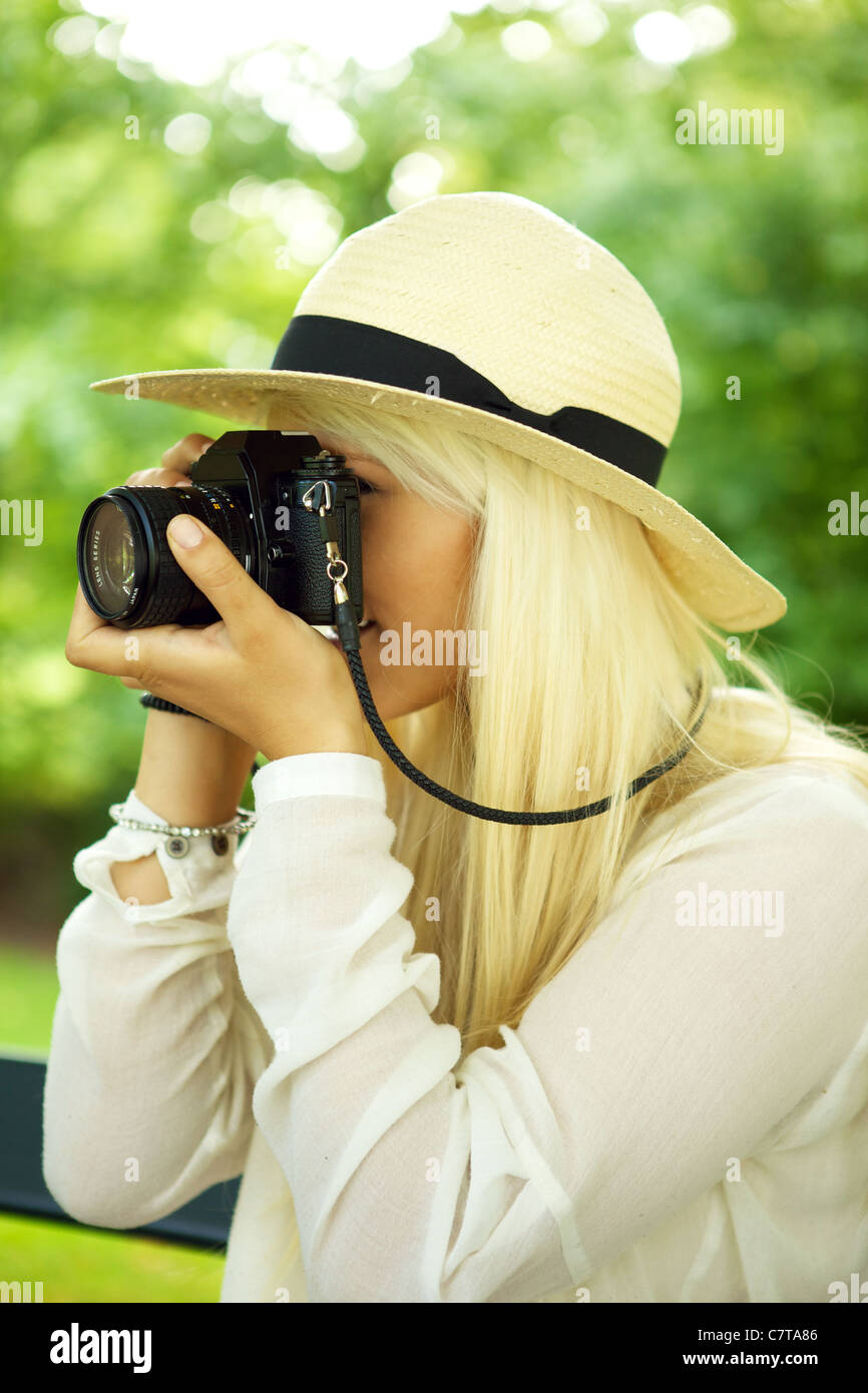 Jeune femme belle de prendre une photo dans un parc. Banque D'Images