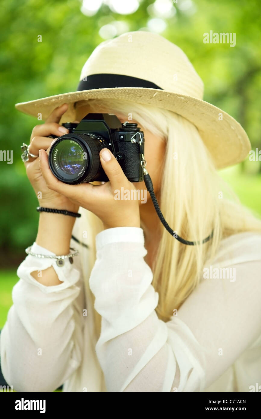 Femme photographe de prendre une photo dans un parc. Banque D'Images