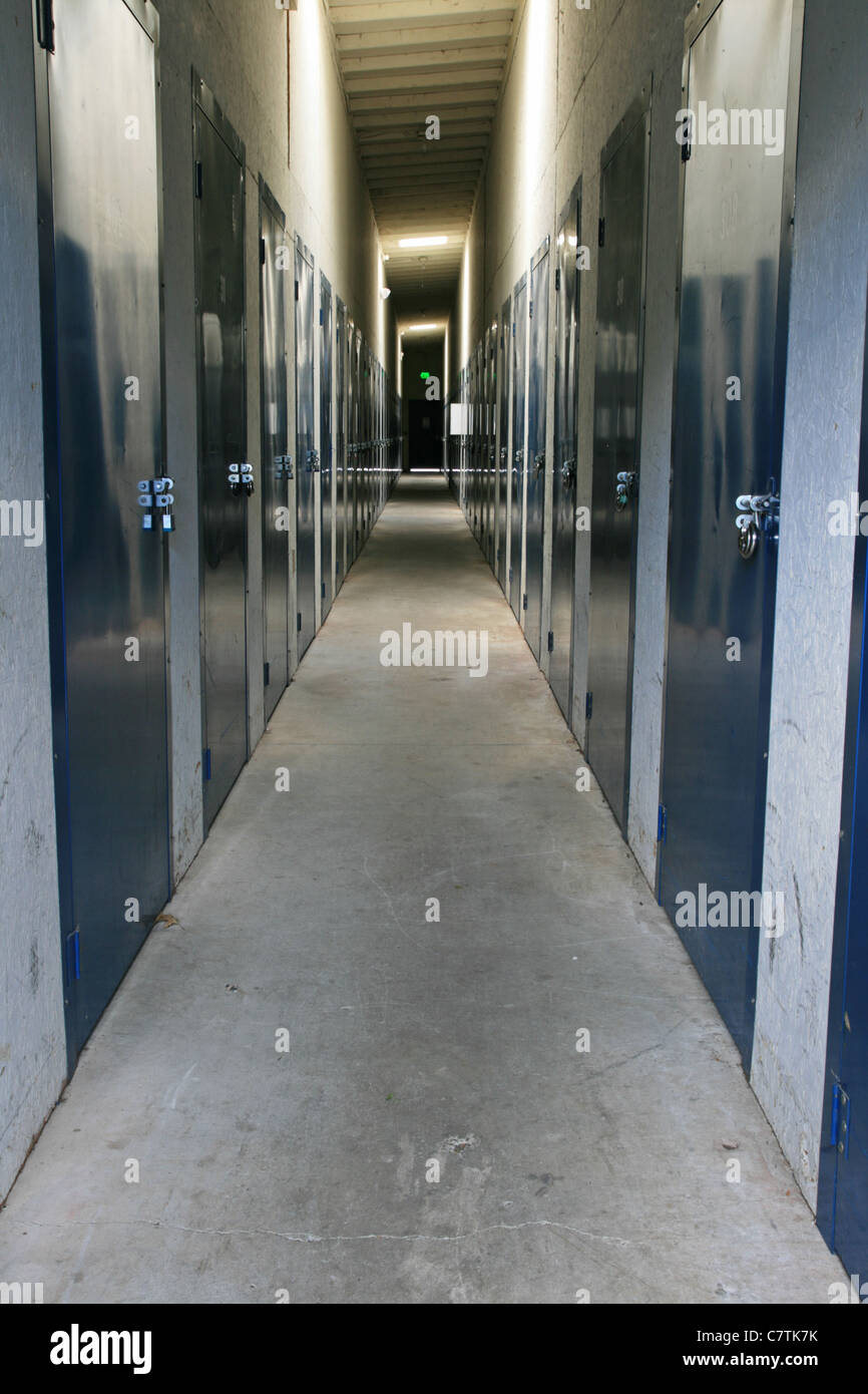 Vue vers le bas d'un corridor dans une unité de stockage autonome avec de chaque côté des portes cadenassées Banque D'Images