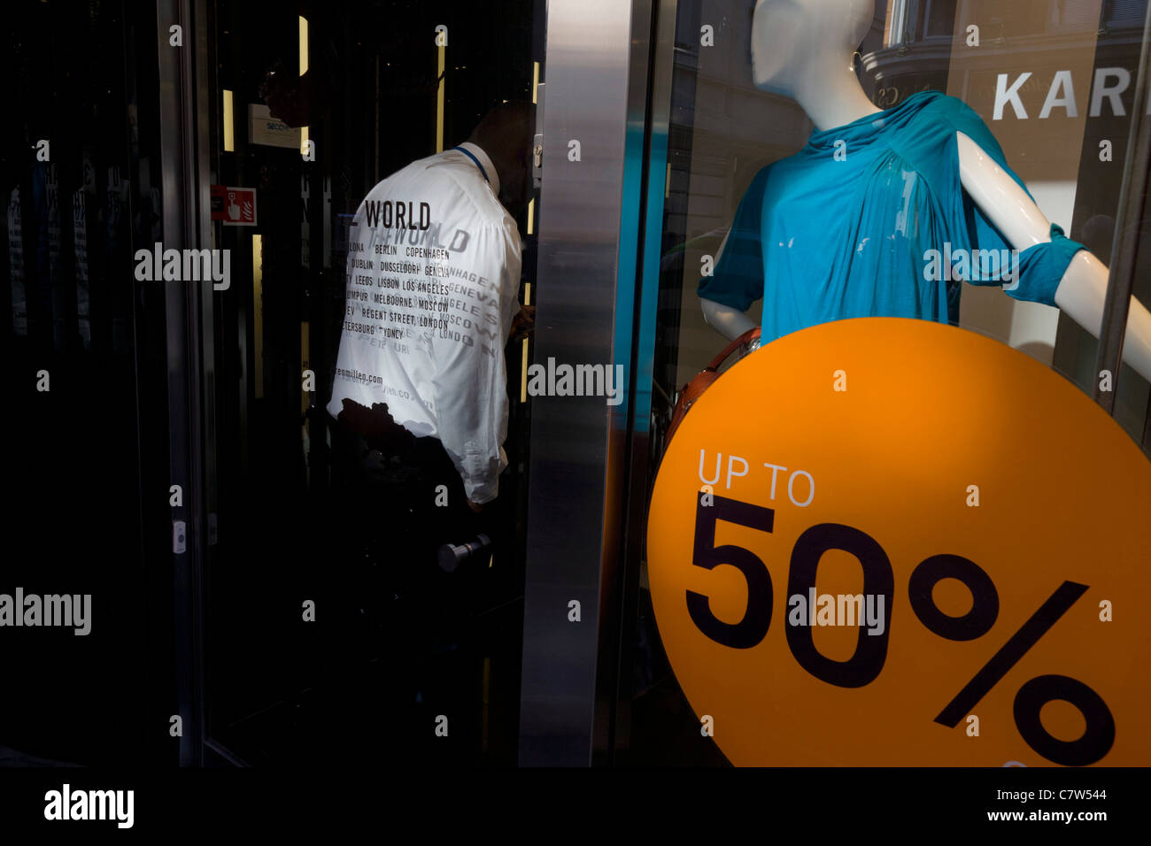 Un garde de sécurité se tient discrètement à proximité de la sortie d'une succursale de la marque de vêtements Karen Millen dans le centre de Londres. Banque D'Images