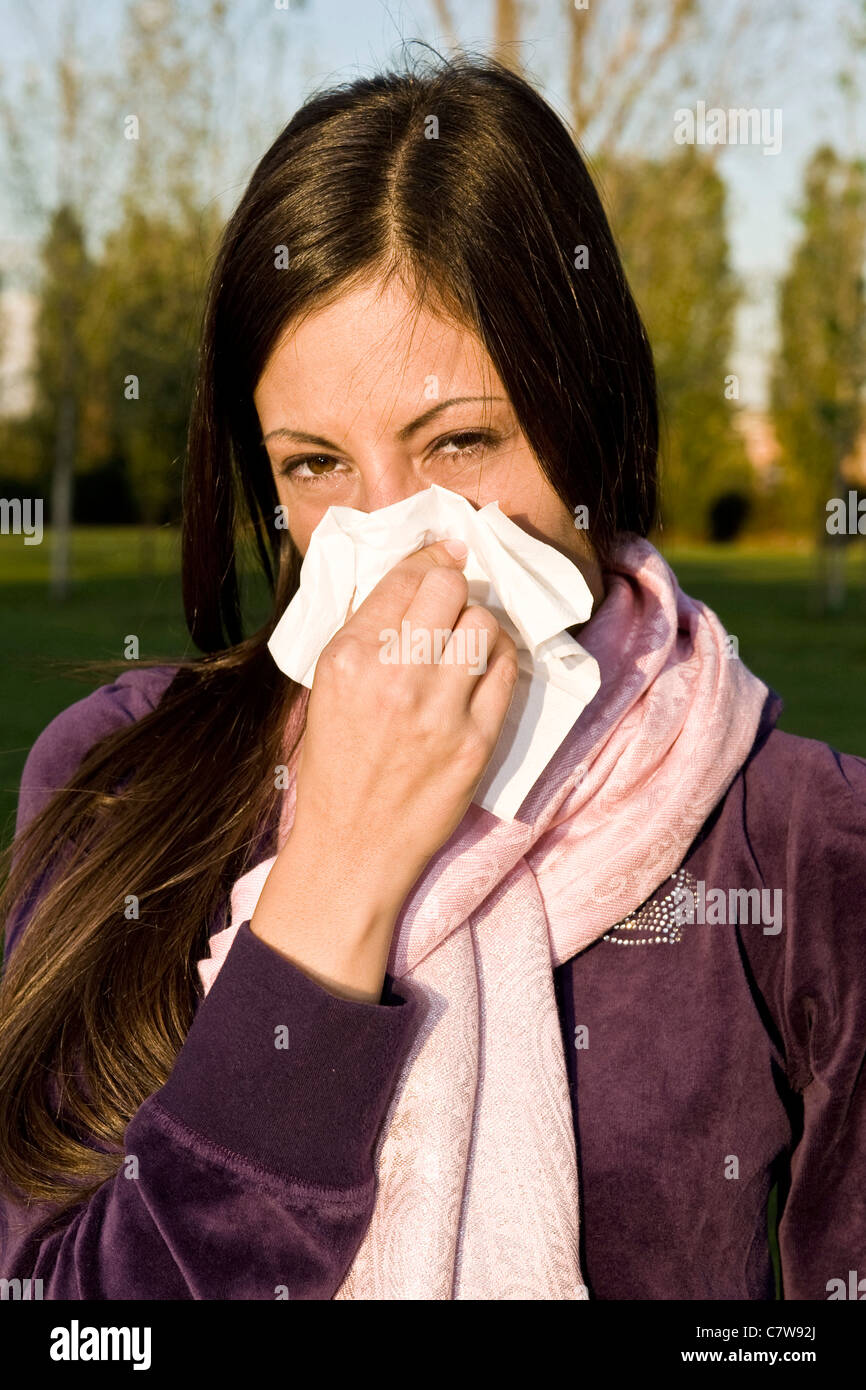 Young woman blowing nose Banque D'Images