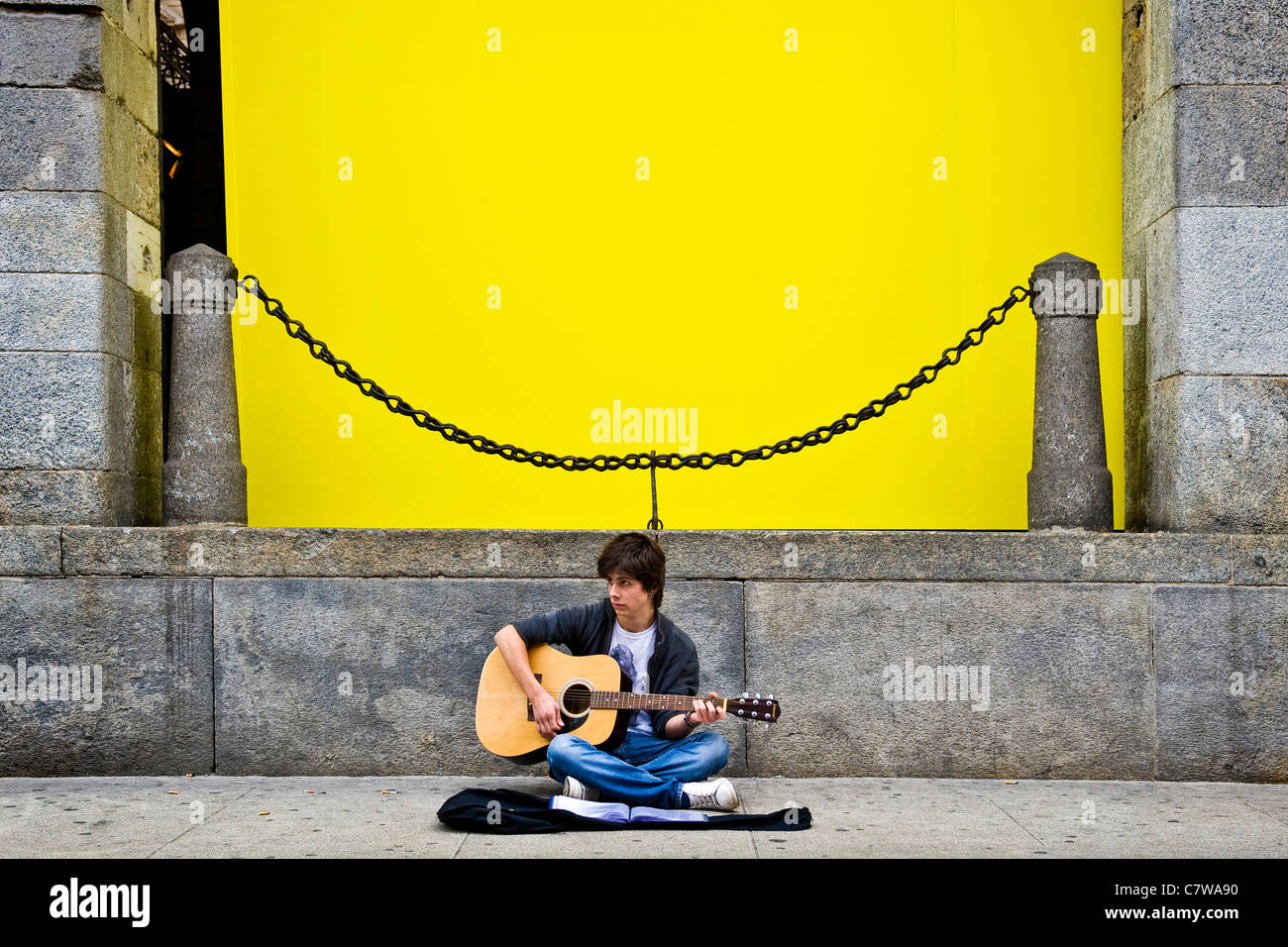 Adolescent qui joue de la guitare dans la rue Banque D'Images