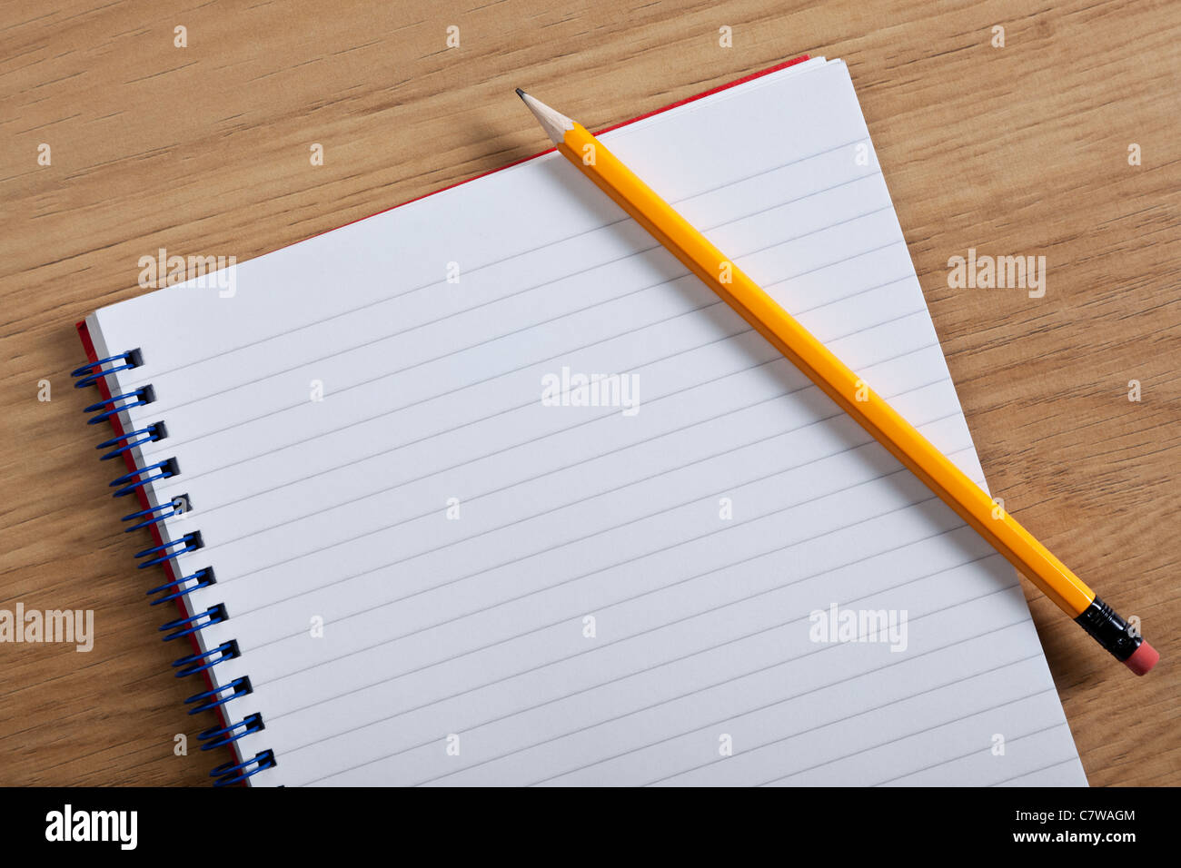 Photo d'un blanc a jugé le bloc-notes et crayon sur un bureau, ajouter votre propre copie. Banque D'Images