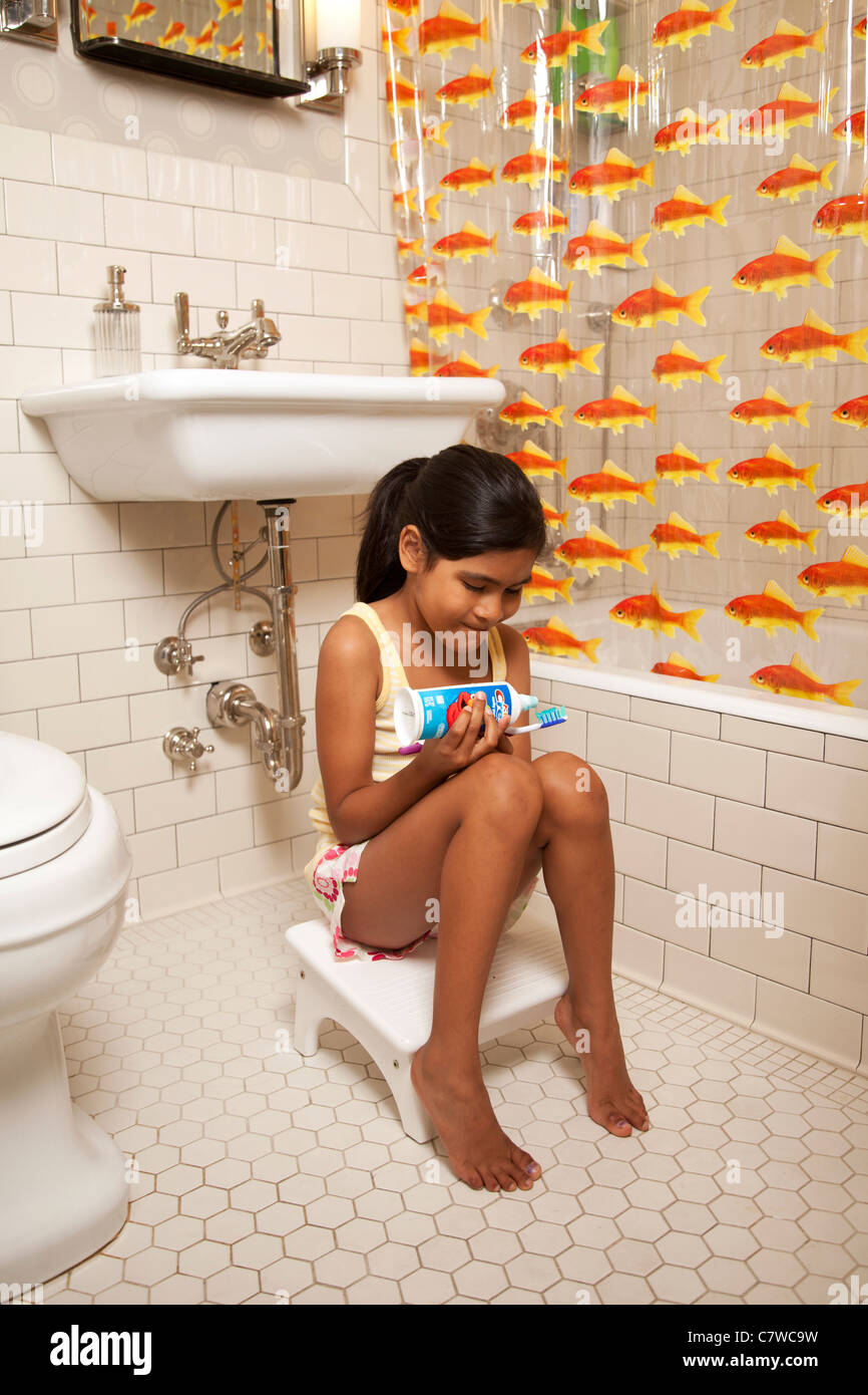 Jeune fille dans la salle de bain se brosser les dents Banque D'Images