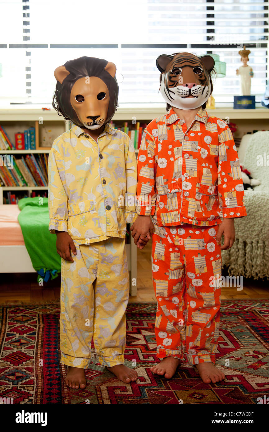 Deux enfants avec les masques sur en pyjama Banque D'Images