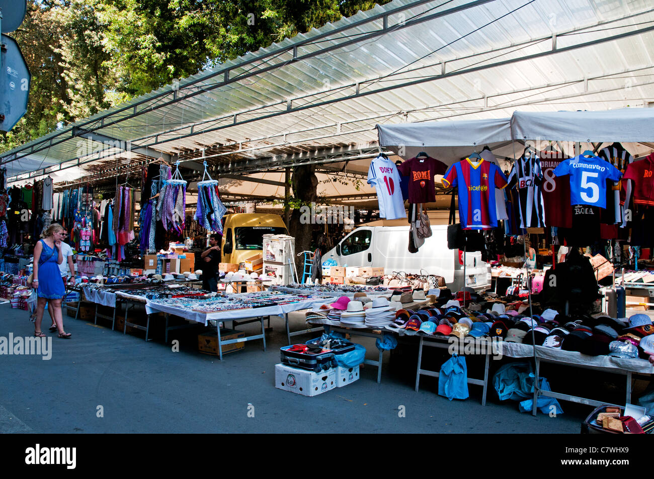 Consommateurs à la recherche de certains des choix de biens en vente sur le marché en plein air, Civitavecchia, Italie Banque D'Images