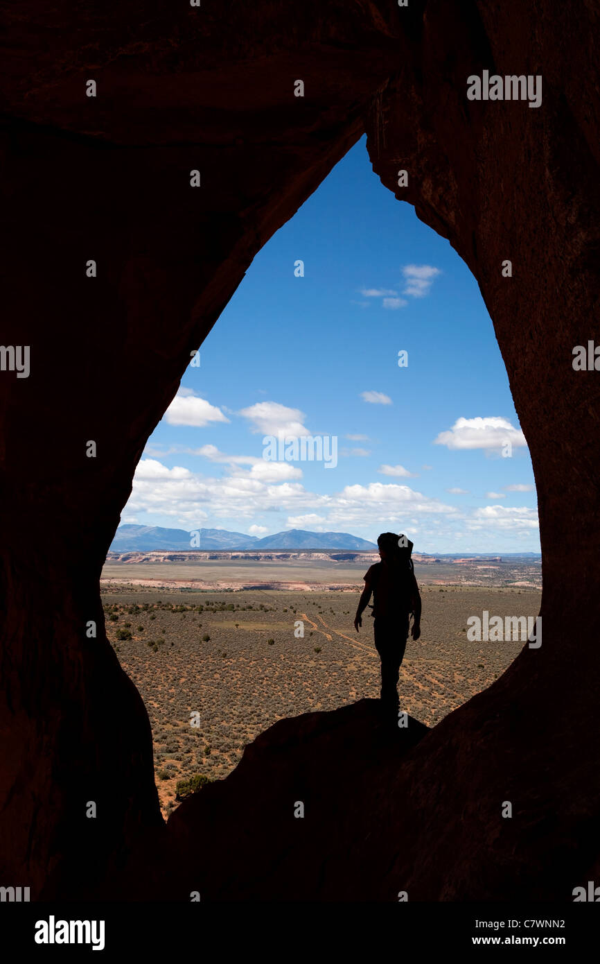 En grimpant à la fenêtre en verre rock arch près de Moab dans l'Utah USA silhouetté contre le désert et montagnes Sanpete Banque D'Images