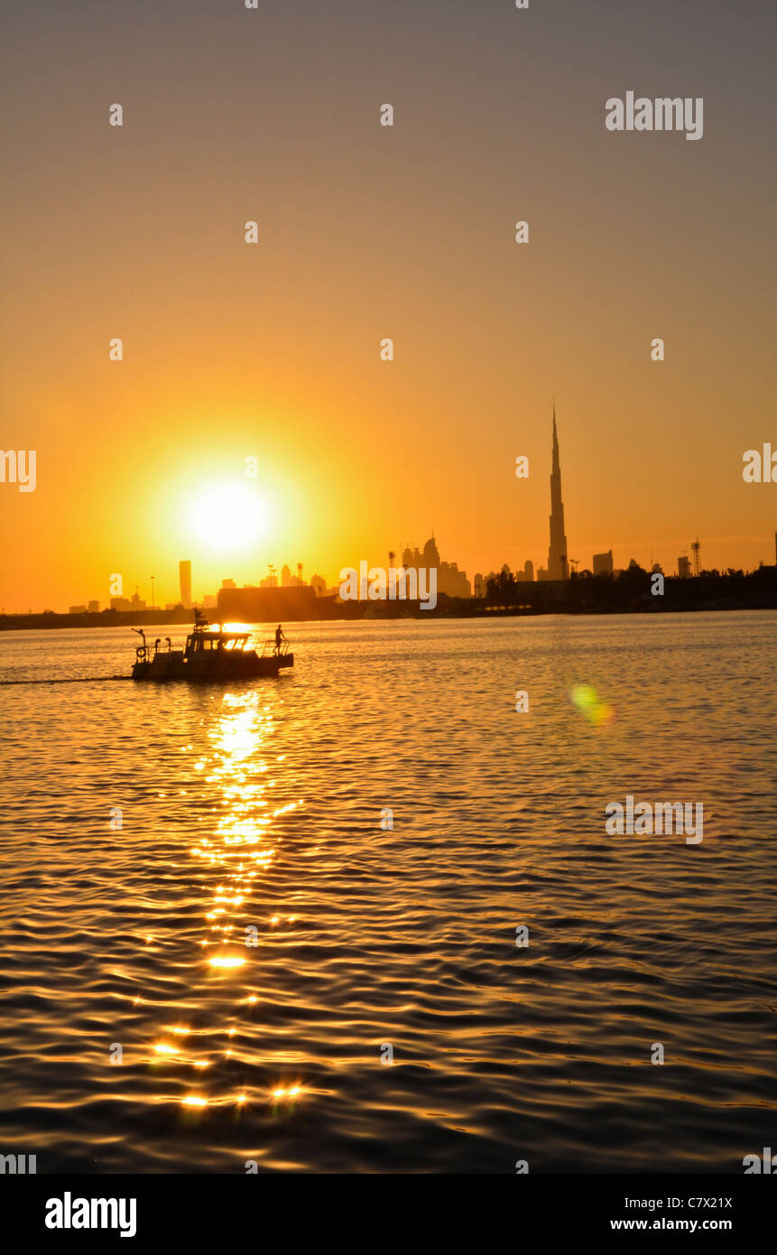 Un homme sur le bateau près de Burj Khalifa Dubaï au coucher du soleil Banque D'Images