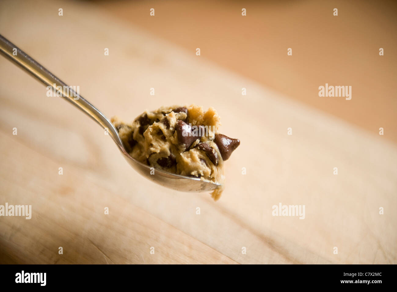 Sur une pâte à biscuits cuillère latte suspendu en milieu de l'image du flou de bois en arrière-plan Banque D'Images