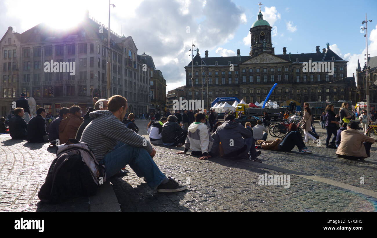 Les gens assis à proximité du Palais Royal (Koninklijk Paleis), Dam Square, Amsterdam, Pays-Bas. Banque D'Images