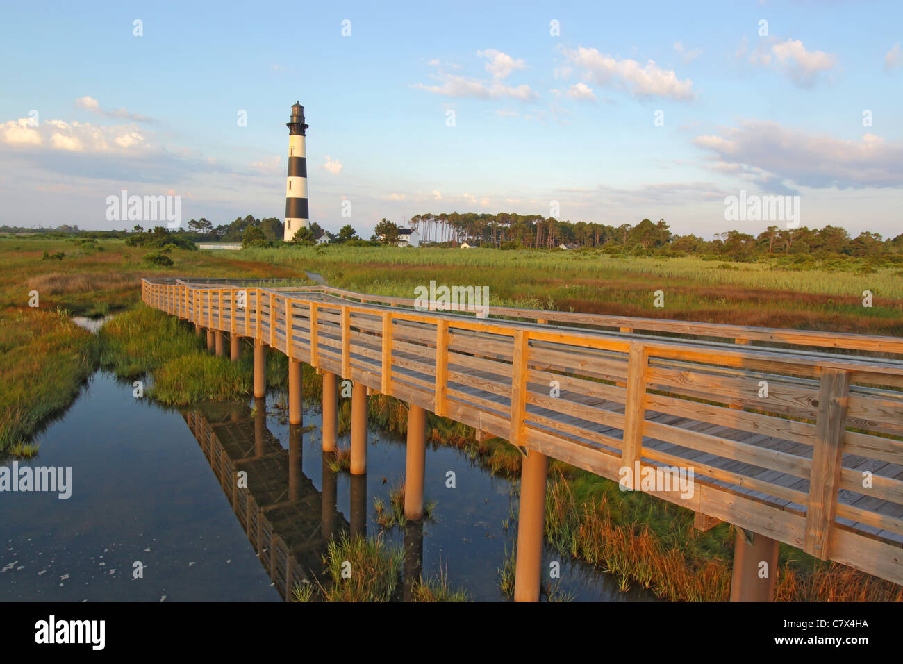 Passerelle en bois à l'Bodie Island Lighthouse sur les Outer Banks de la Caroline du Nord contre un ciel bleu et nuages blancs Banque D'Images