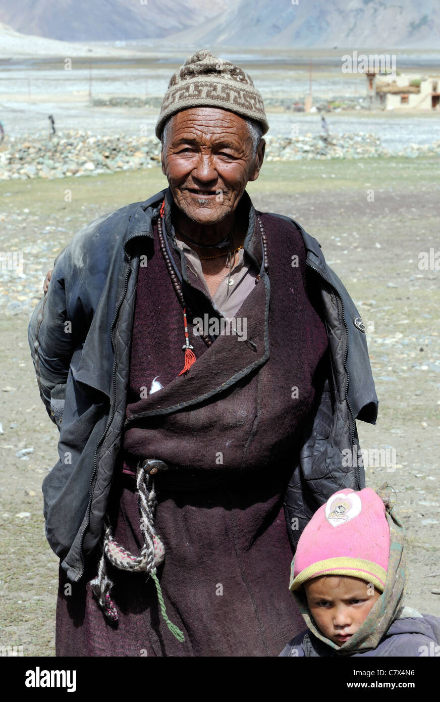 Un homme en costume traditionnel et son petit-fils par le village de Rangdum au Zanskar. Banque D'Images