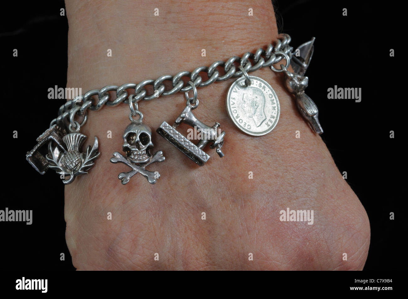 Sterling Silver Charm bracelet sur le poignet de la femme. Banque D'Images
