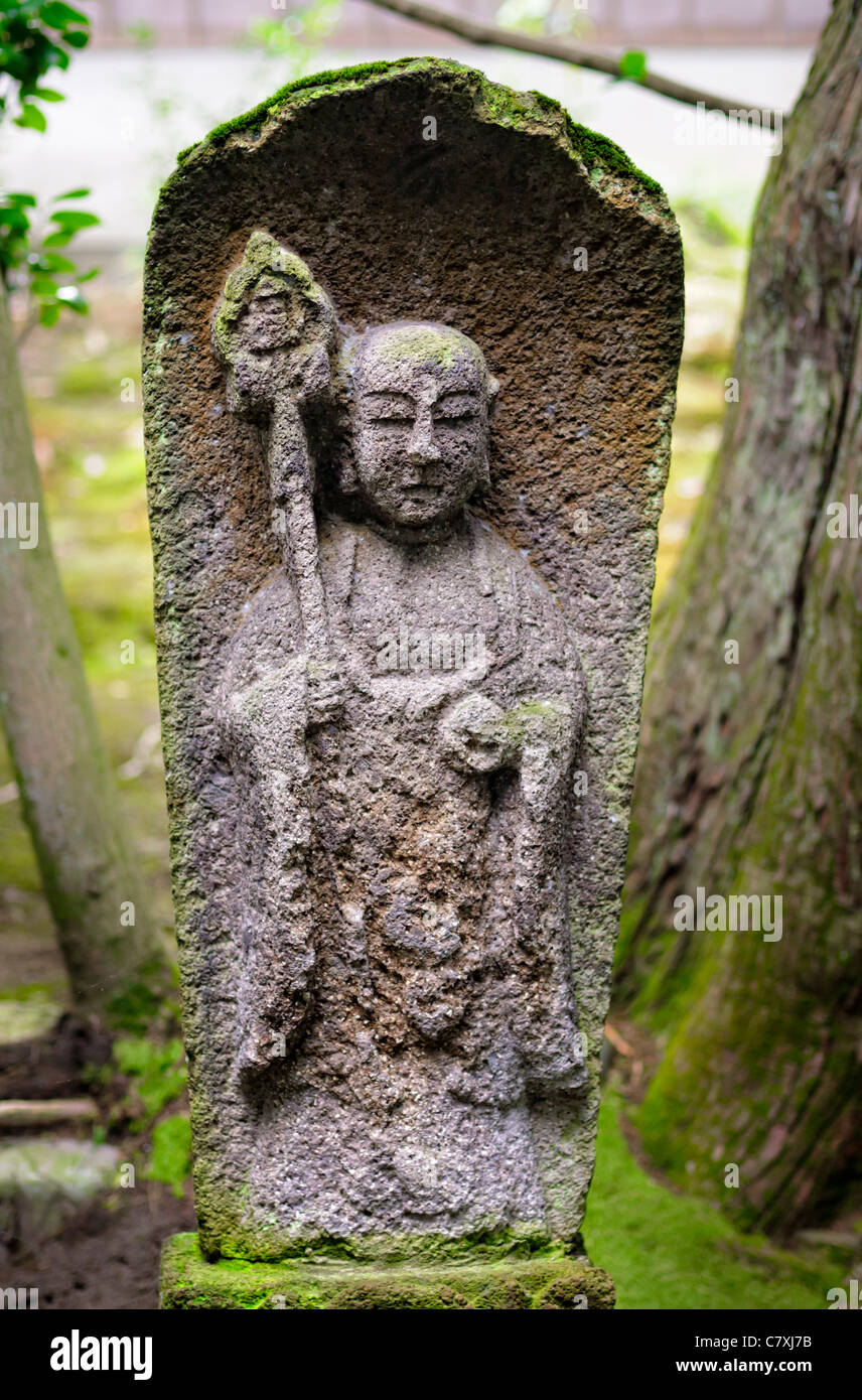 Old weathered statue en pierre de Jizo, bouddhiste Japonais Shinto / tuteur des enfants, dans un ancien jardin au Japon. Bouddhisme ; divinité ; statue religieuse Banque D'Images