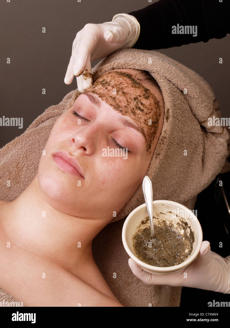 Femme avec les yeux fermés tout en masque peeling chinois des herbes et des algues Les algues est appliqué sur son visage Banque D'Images
