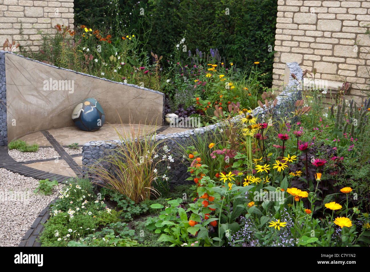 Petite cour de Cottage jardin urbain avec cercle circulaire pierre pavée et patio en gravier mixte frontière d'été limite de couverture Royaume-Uni Banque D'Images