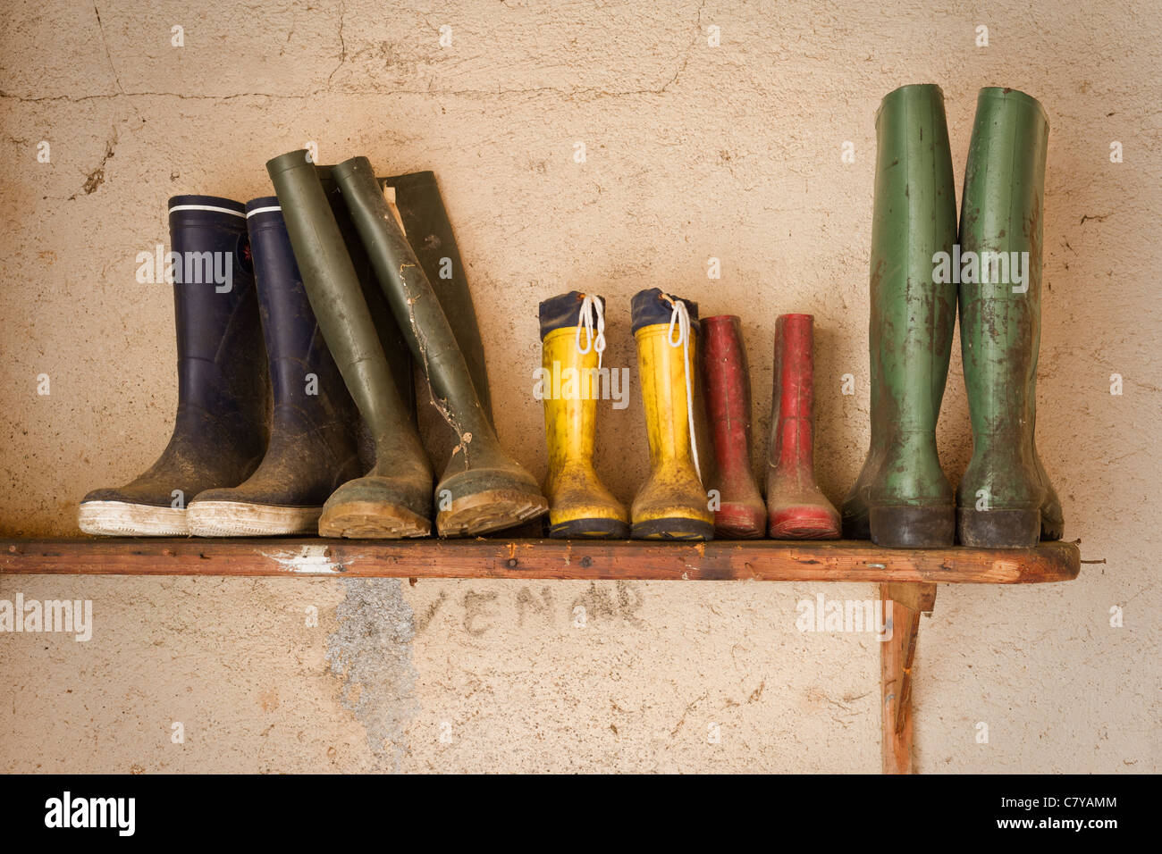 Bottes de pluie sale sur plateau en bois Banque D'Images