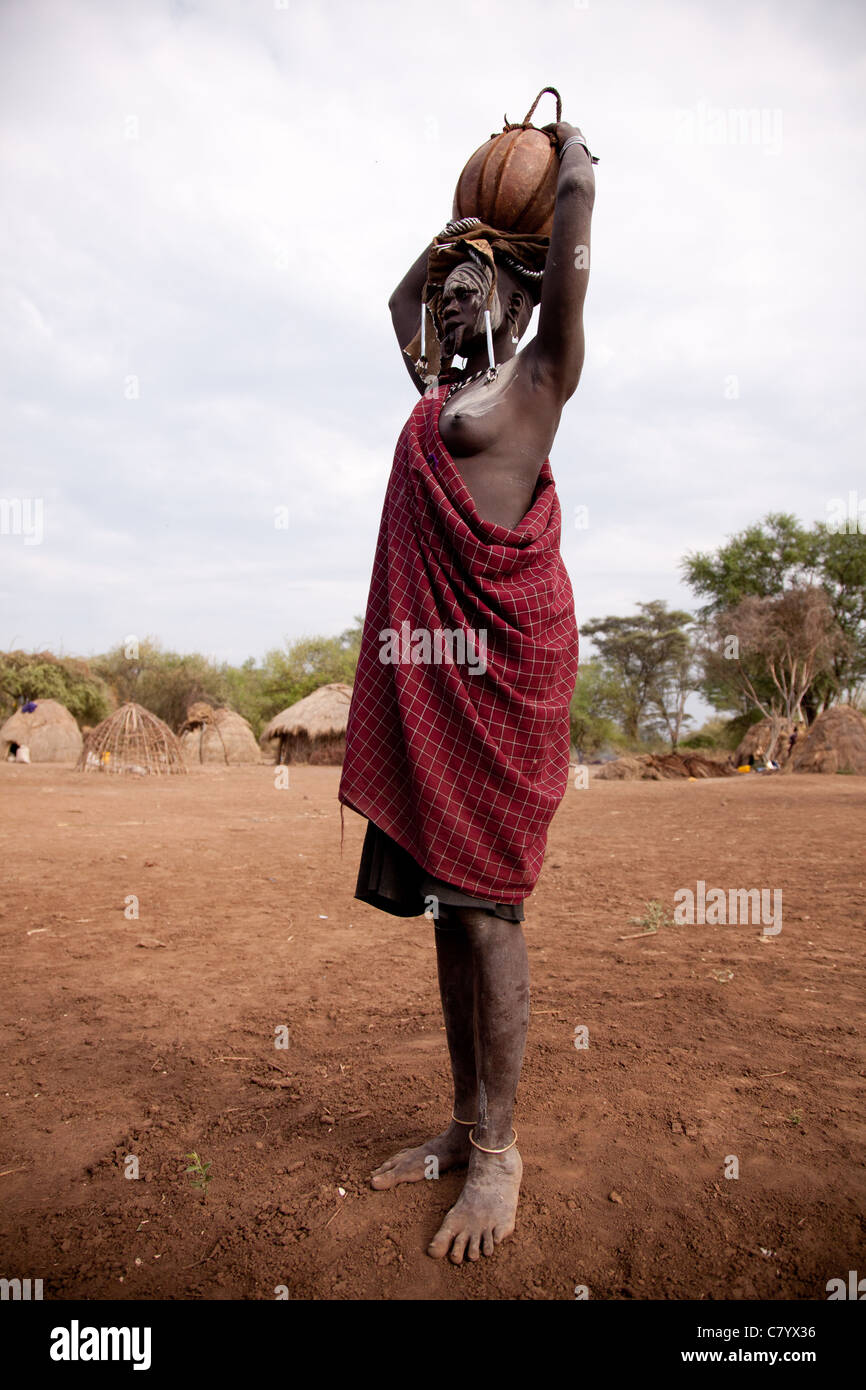 Femme Mursi portant de l'eau pot sur la tête, Jinka, vallée de l'Omo, Ethiopie, Afrique Banque D'Images