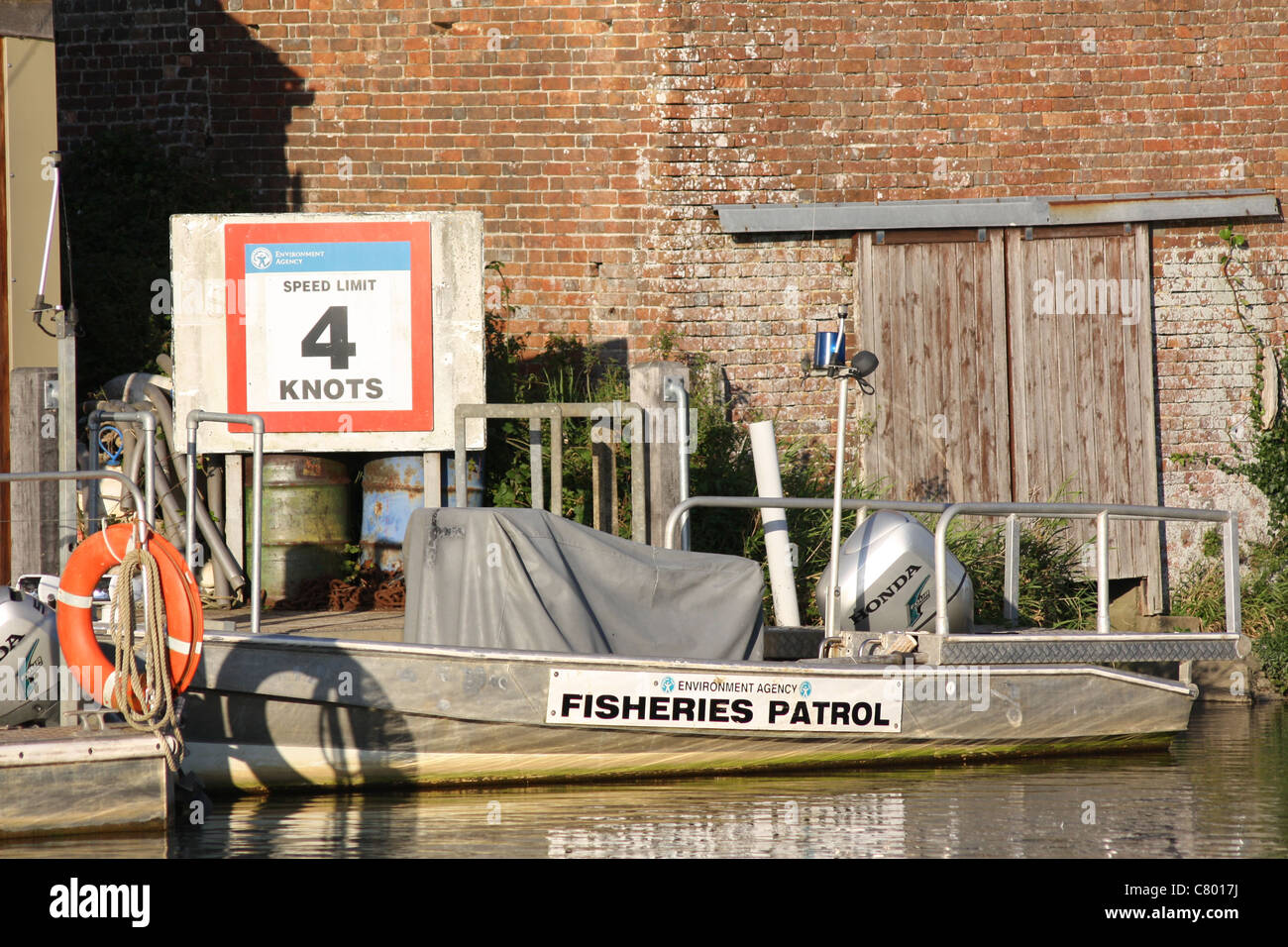 Wareham Dorset Agence de l'environnement Patrouille de pêche sur la rivière Frome Wareham Dorset. Bateau amarré par 4 noeuds de limite de vitesse de rivière signe Banque D'Images