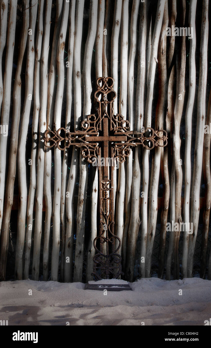 Croix ouvragée en métal laiton contre des bâtons Banque D'Images