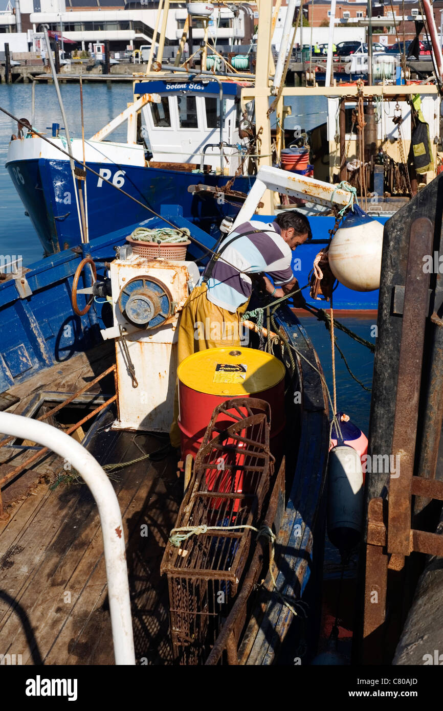 Pêcheur en mer profonde à travailler sur son bateau dans le port Banque D'Images