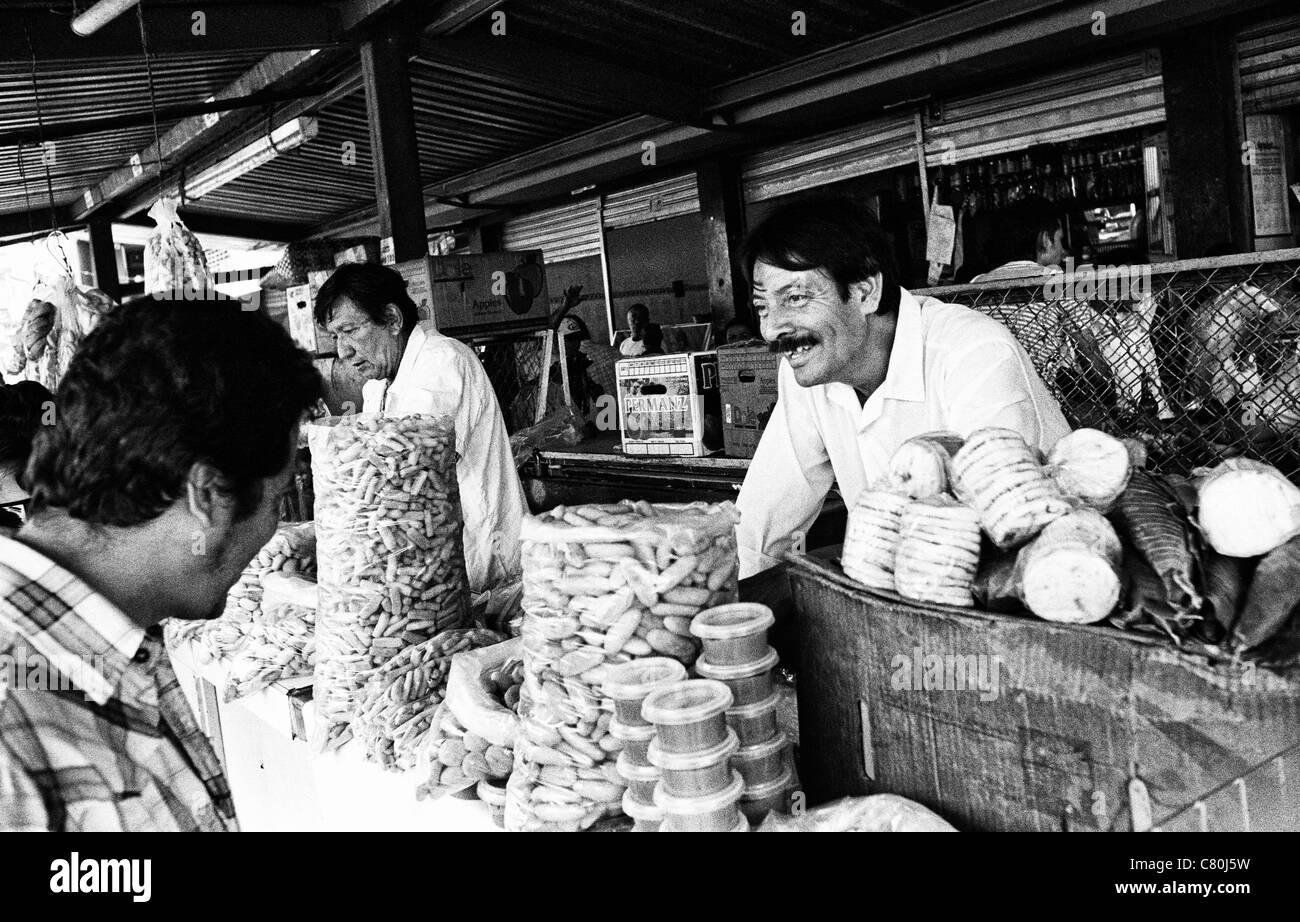 Ventes d'aliments traditionnels et des gâteaux base de maïs sur le marché avec un client. Ibagué, Tolima, Colombie, Amérique du Sud Banque D'Images