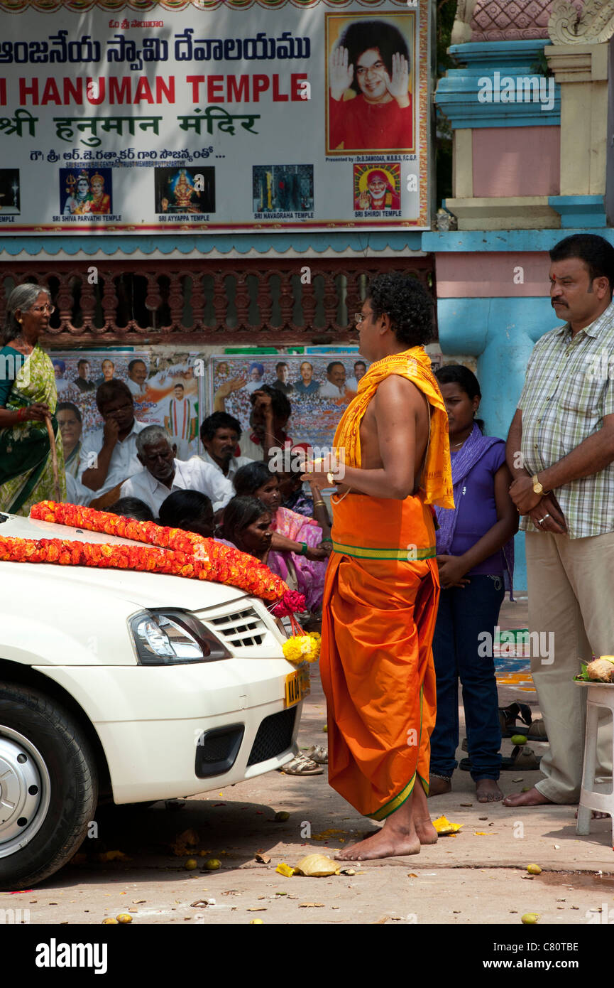 Prêtre hindou bénédiction une voiture pendant le festival du Dasara avant de faire un voyage. Puttaparthi, Andhra Pradesh, Inde Banque D'Images