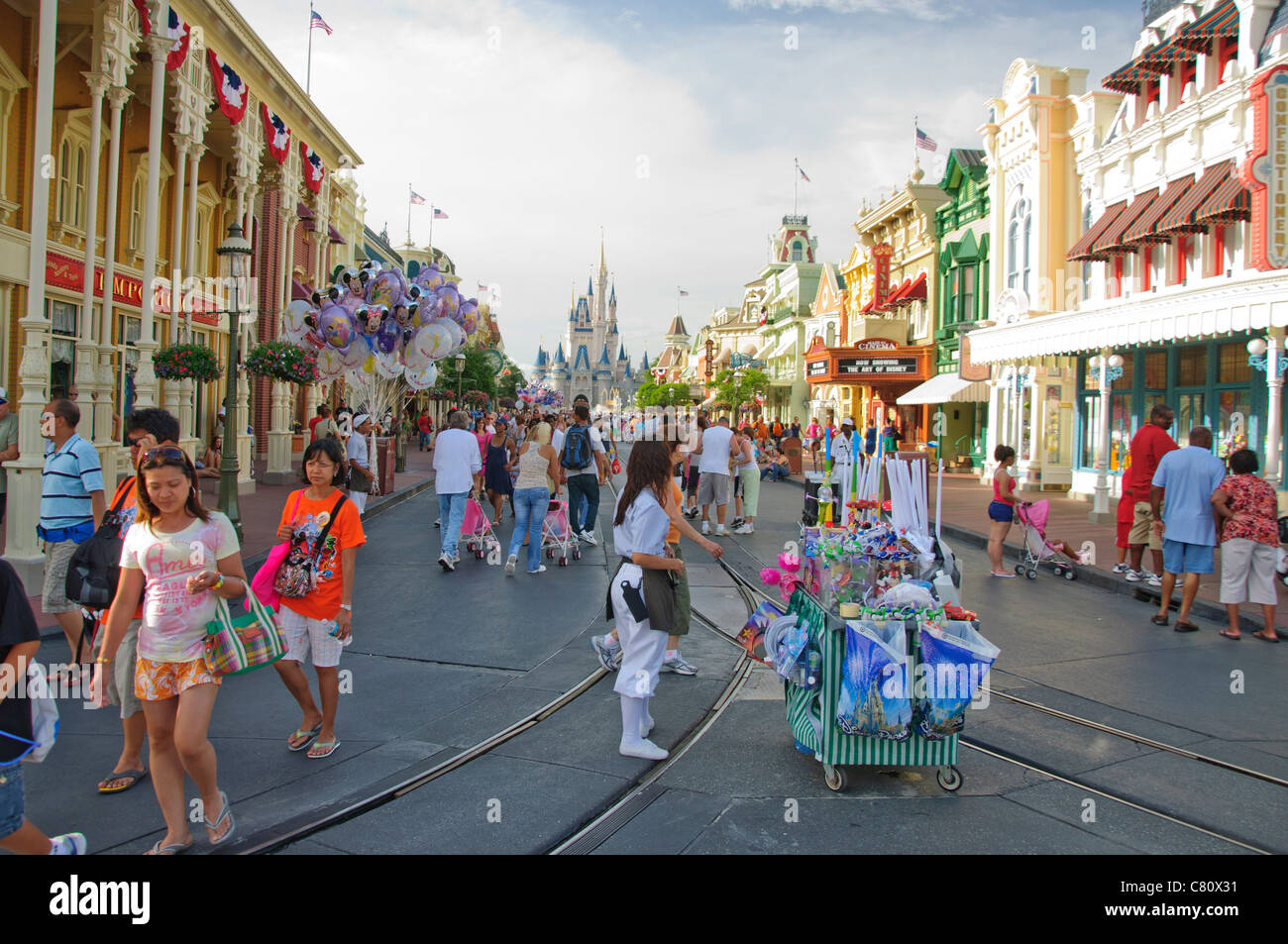Main Street Usa Magic Kingdom en Floride avec des amuseurs publics et des personnes et des étals de vente mobile Banque D'Images