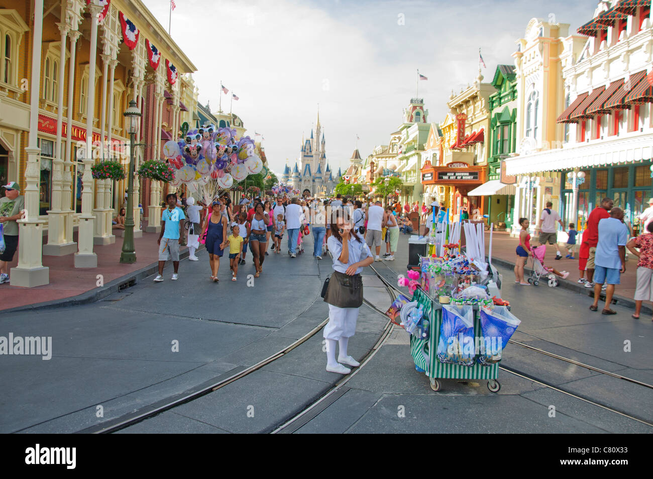 Main Street Usa Magic Kingdom en Floride avec des amuseurs publics et des personnes et des étals de vente mobile Banque D'Images