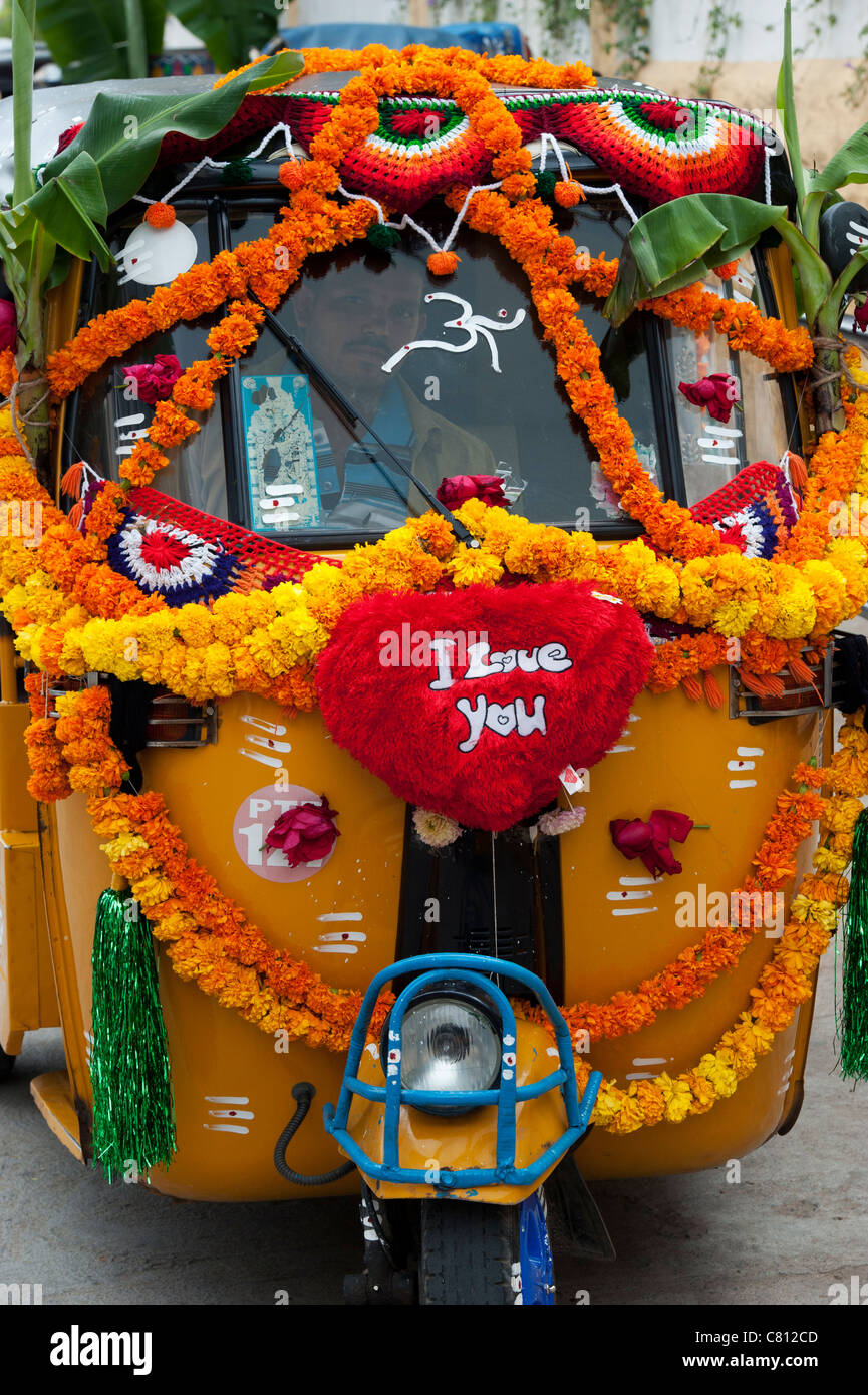 Rickshaw indien décorées de guirlandes de fleurs et de feuilles de bananier au cours de la fête hindoue du Dasara. L'Andhra Pradesh, Inde Banque D'Images Rickshaw indien décorées de guirlandes de fleurs et de feuilles de bananier au cours de la fête hindoue du Dasara. L'Andhra Pradesh, Inde Banque D'Images