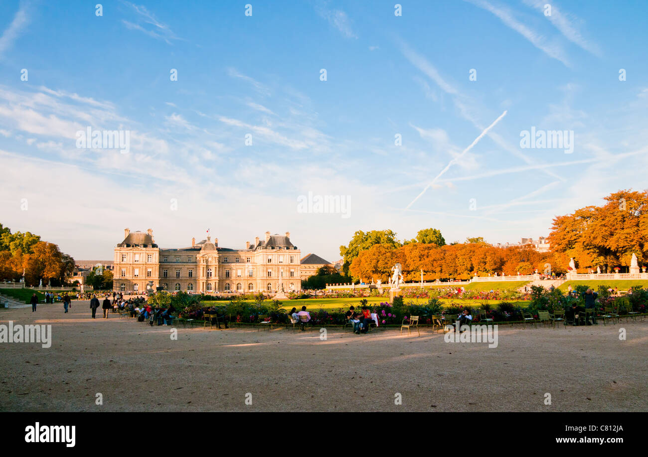 Jardin du Luxembourg avec le palais et statue. Peu de fleurs sont à l'avant et le ciel bleu derrière. Banque D'Images
