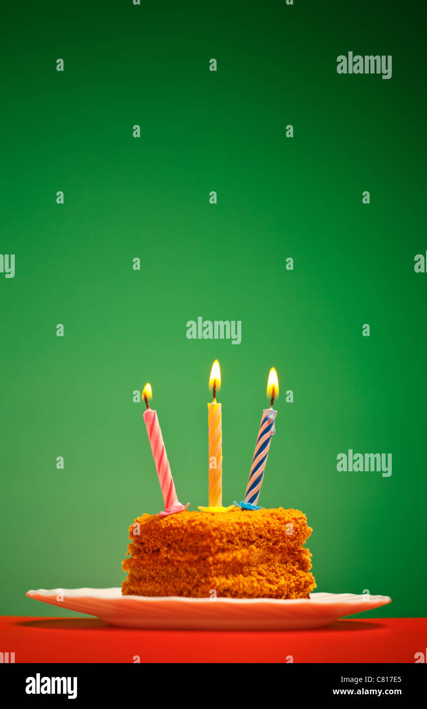 Gâteau d'anniversaire avec une bougie sur fond rose Banque D'Images