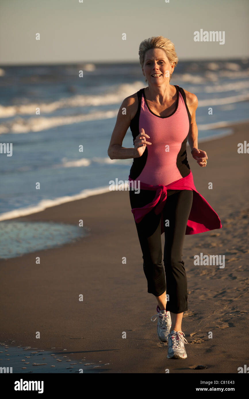 Woman running on beach Banque D'Images
