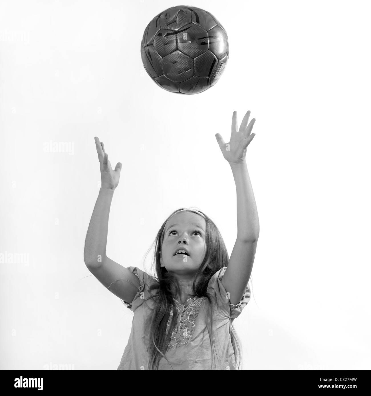 Huit ans, fille de lancer une balle en l'air Banque D'Images