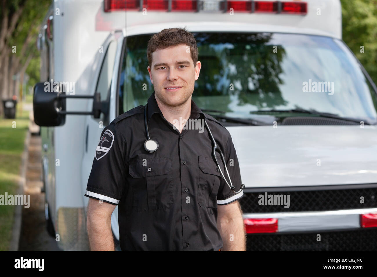 Portrait de jeune paramedic in front of white ambulance Banque D'Images