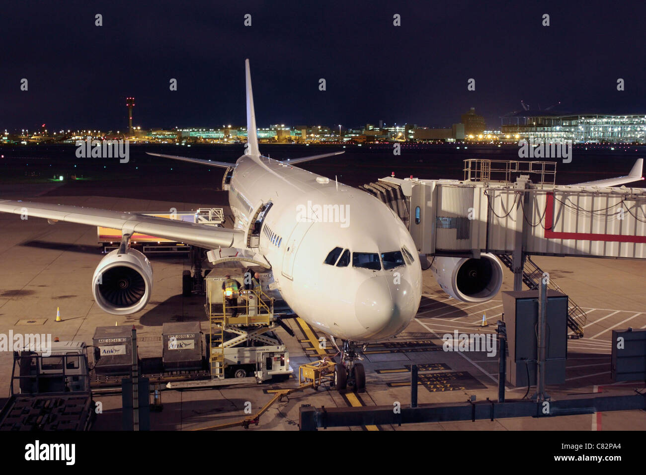 Avion de ligne Airbus A330-200 non marquées à sa porte à l'aéroport d'Heathrow Terminal 4, avec air cargo d'être chargées à bord. La logistique du transport aérien. Banque D'Images