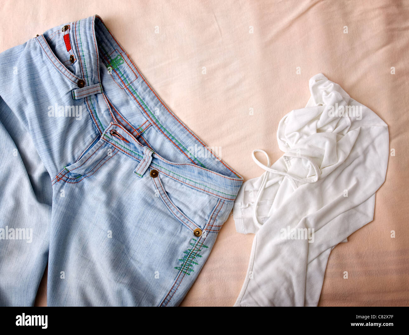 Pantalon et chemise froissée étaient jetés sur le lit dans chambre adolescents. Banque D'Images