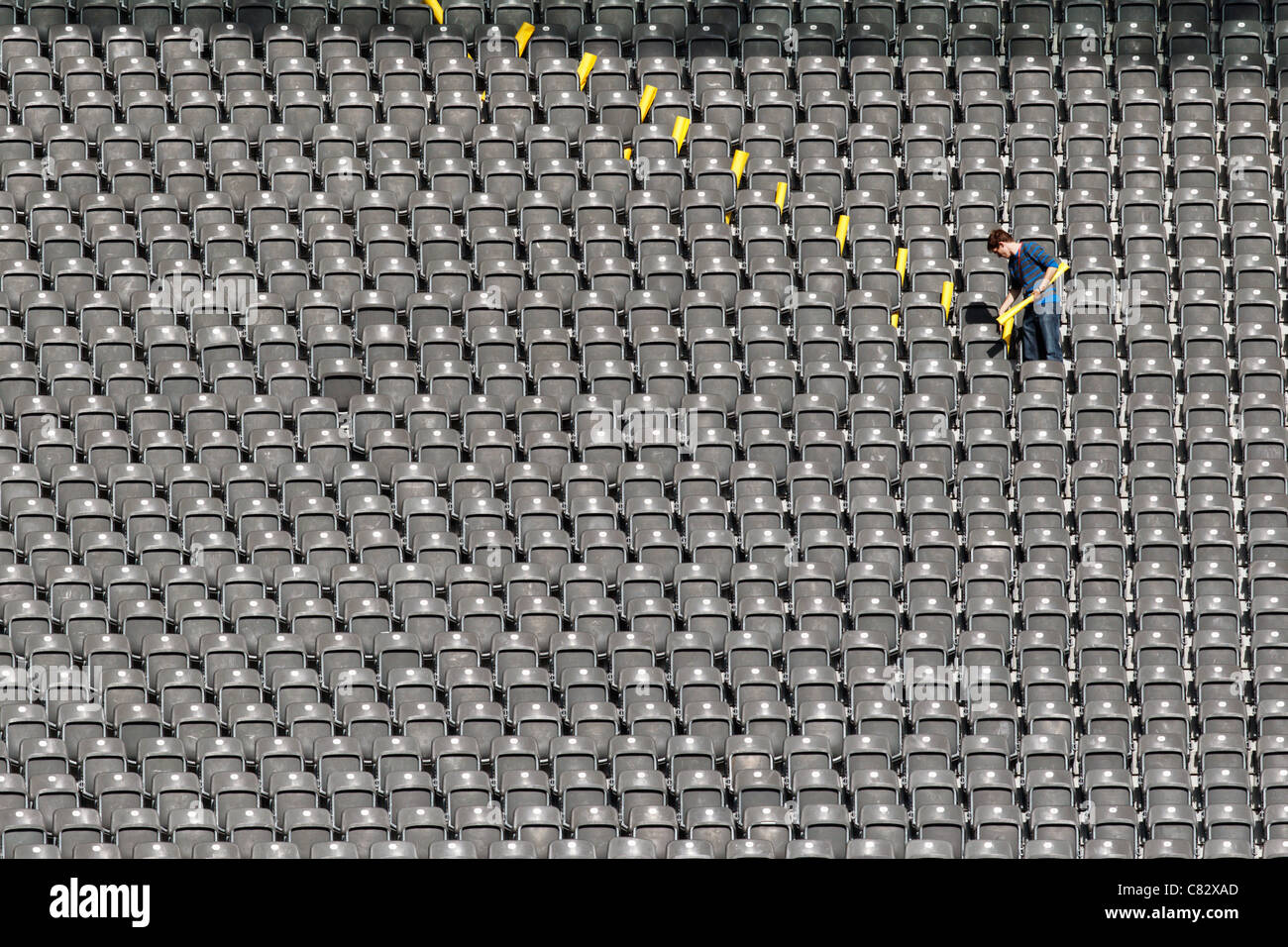 Un ouvrier pose des pancartes jaunes à des places prédéfinies dans le stade olympique à la veille du match d'ouverture de la Coupe du monde de football féminine de la FIFA 2011. Banque D'Images