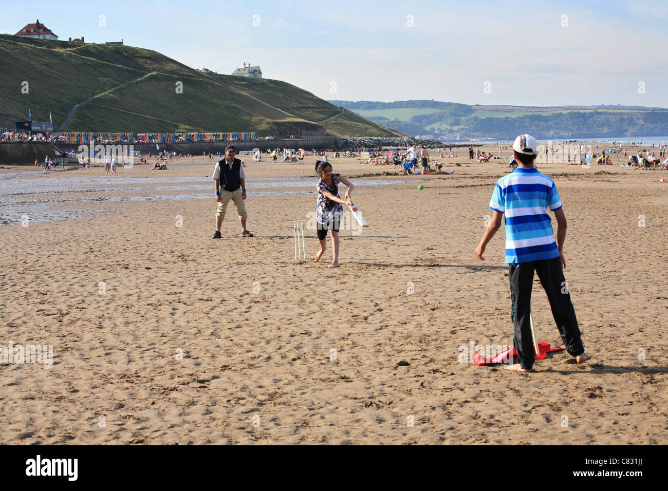 Famille d'apparence asiatique jouer au cricket sur la plage à Whitby, dans le Yorkshire, Angleterre du Nord-Est Banque D'Images