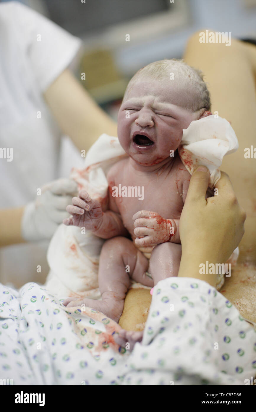 Bébé nouveau-né sur la poitrine de la mère dans la salle immédiatement après la naissance Banque D'Images