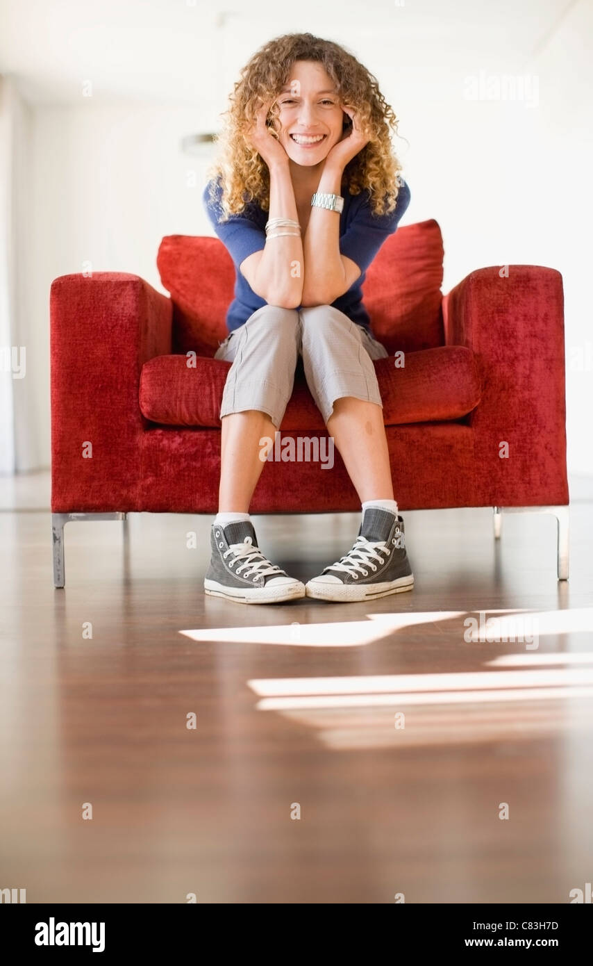 Woman sitting in armchair Banque D'Images