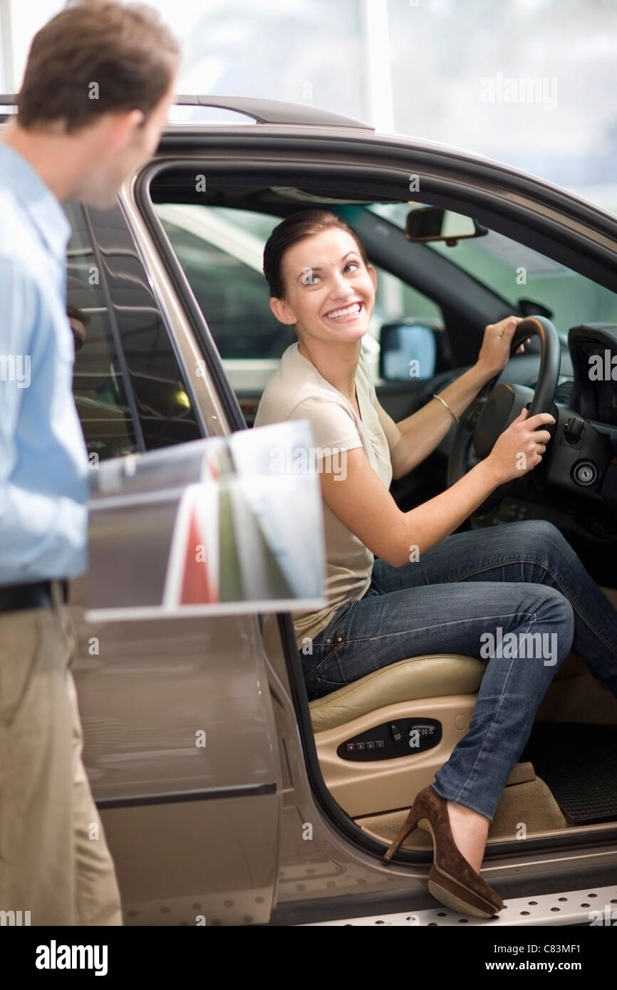 Woman admiring car in showroom Banque D'Images