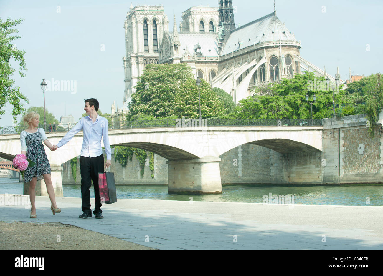 Couple marchant le long de la rivière de la ville près de Notre Dame Banque D'Images