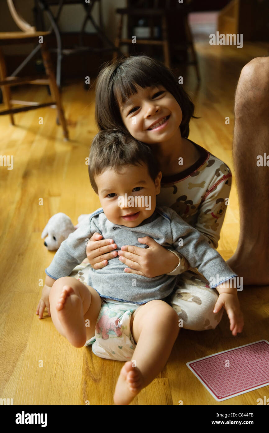Mixed Race girl holding baby brother Banque D'Images
