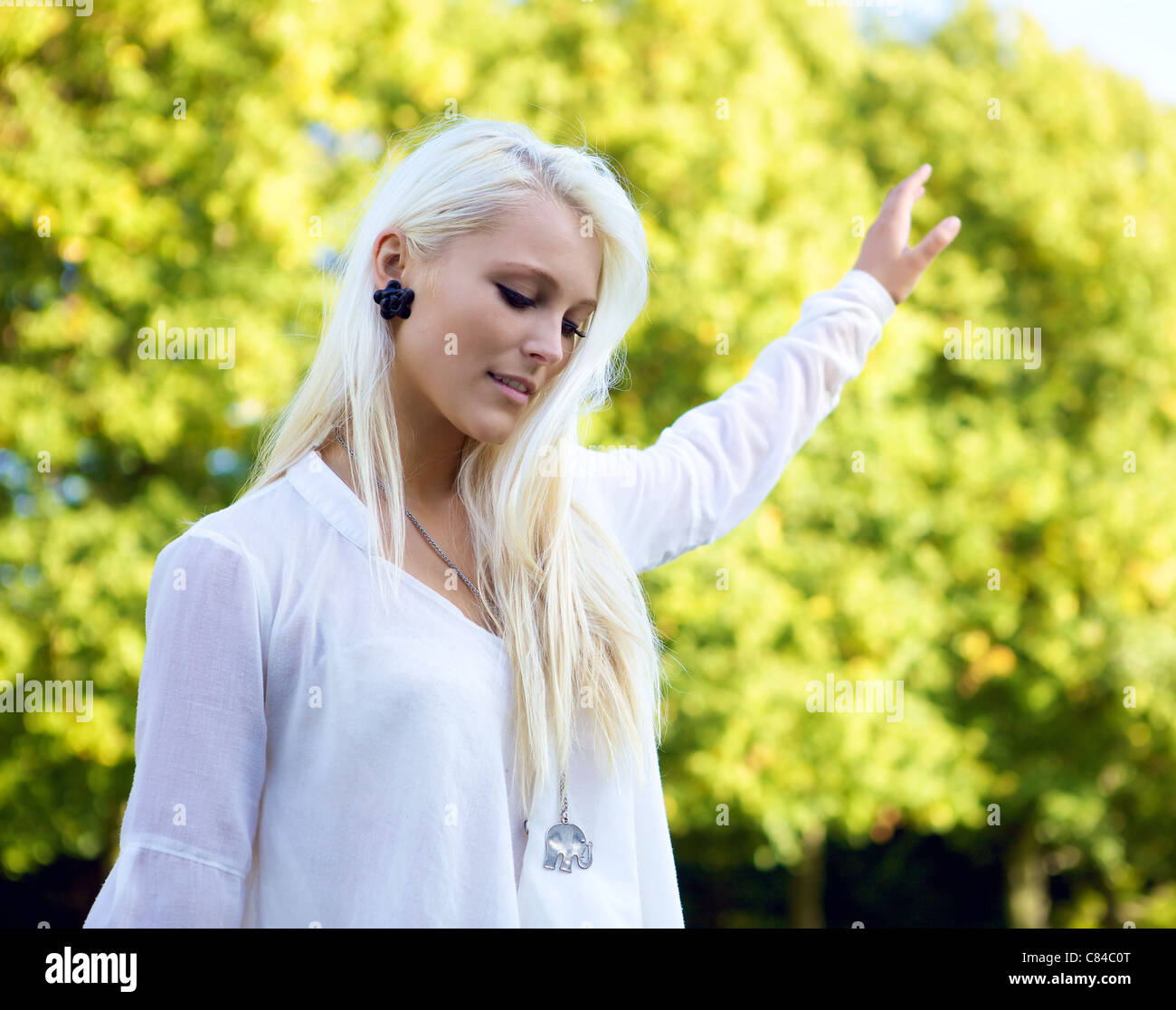Young casual woman balancing dans un parc verdoyant. Banque D'Images