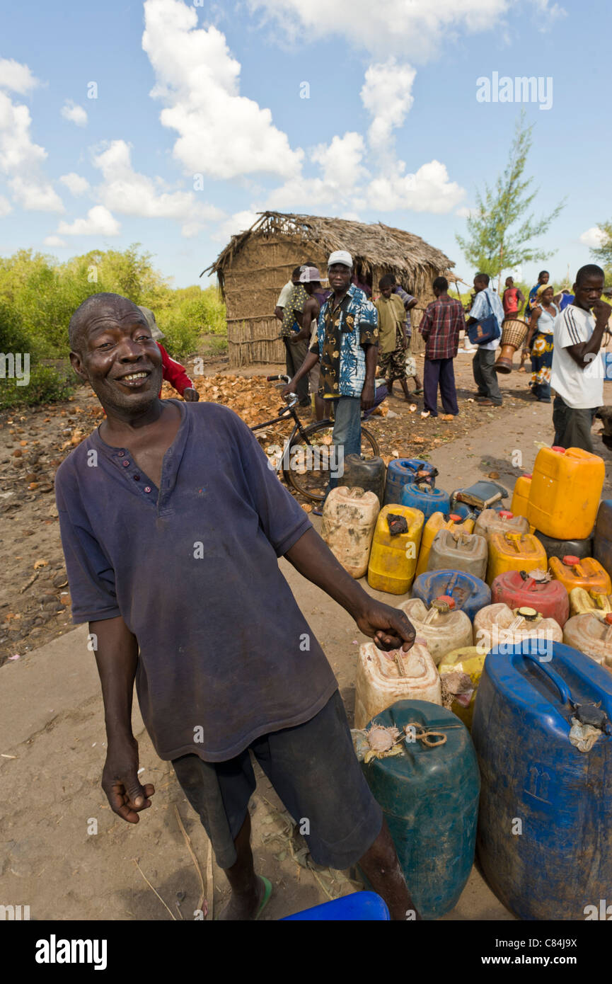 Les gens de l'extraction de l'eau potable dans des contenants d'un robinet public, Quelimane, au Mozambique Banque D'Images