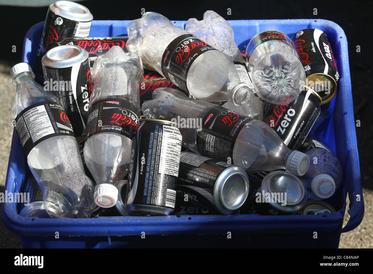 Corbeille bleue pleine de Coke Zero vide les canettes et bouteilles de Coke Zero Banque D'Images