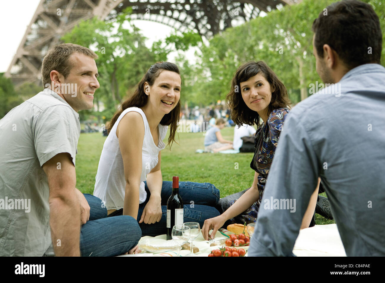 Friends enjoying picnic à la base de la Tour Eiffel, Paris, France Banque D'Images