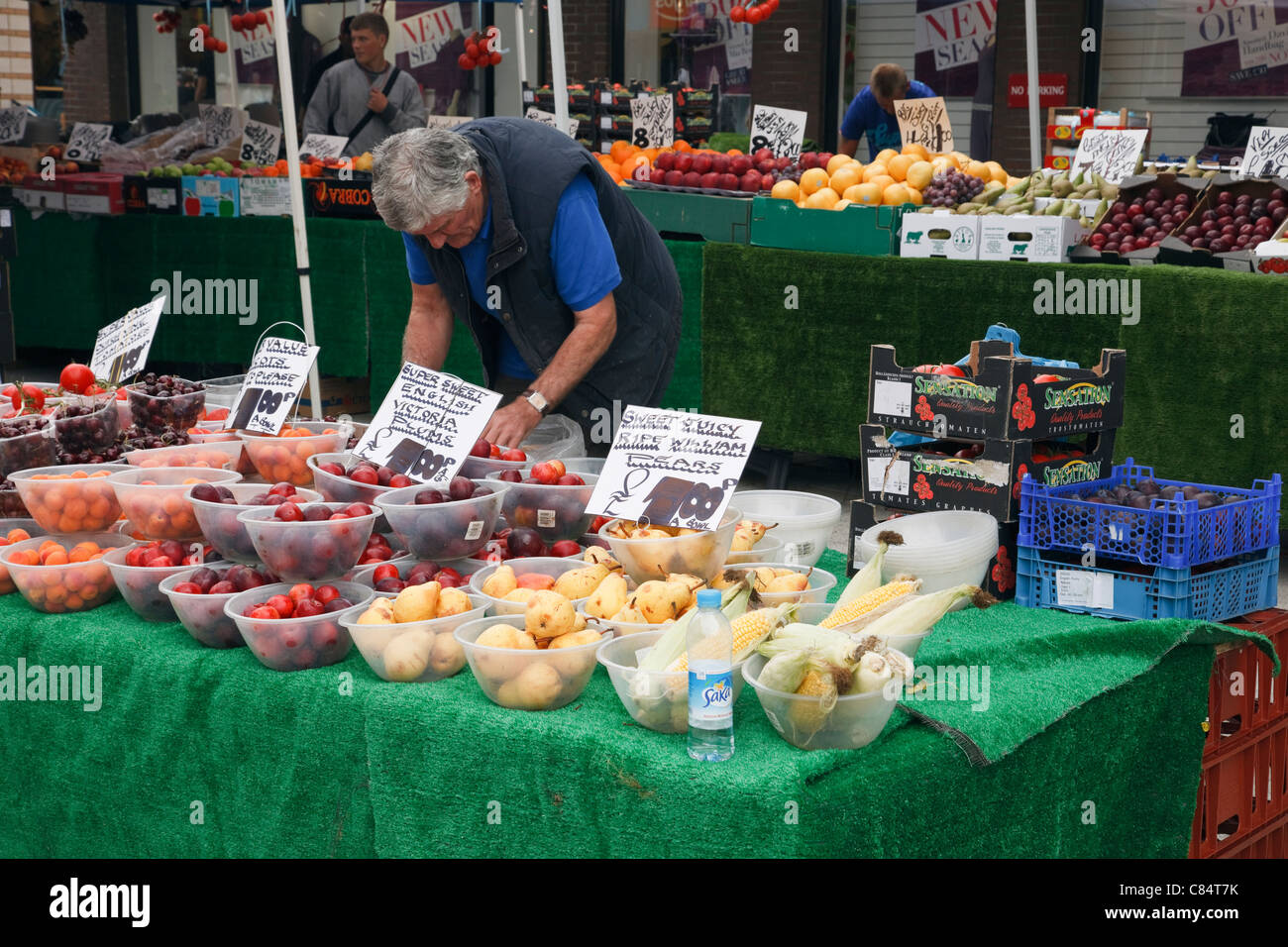 Man selling bols de fruits sur un étal de marché. En Angleterre, Royaume-Uni, Angleterre Banque D'Images
